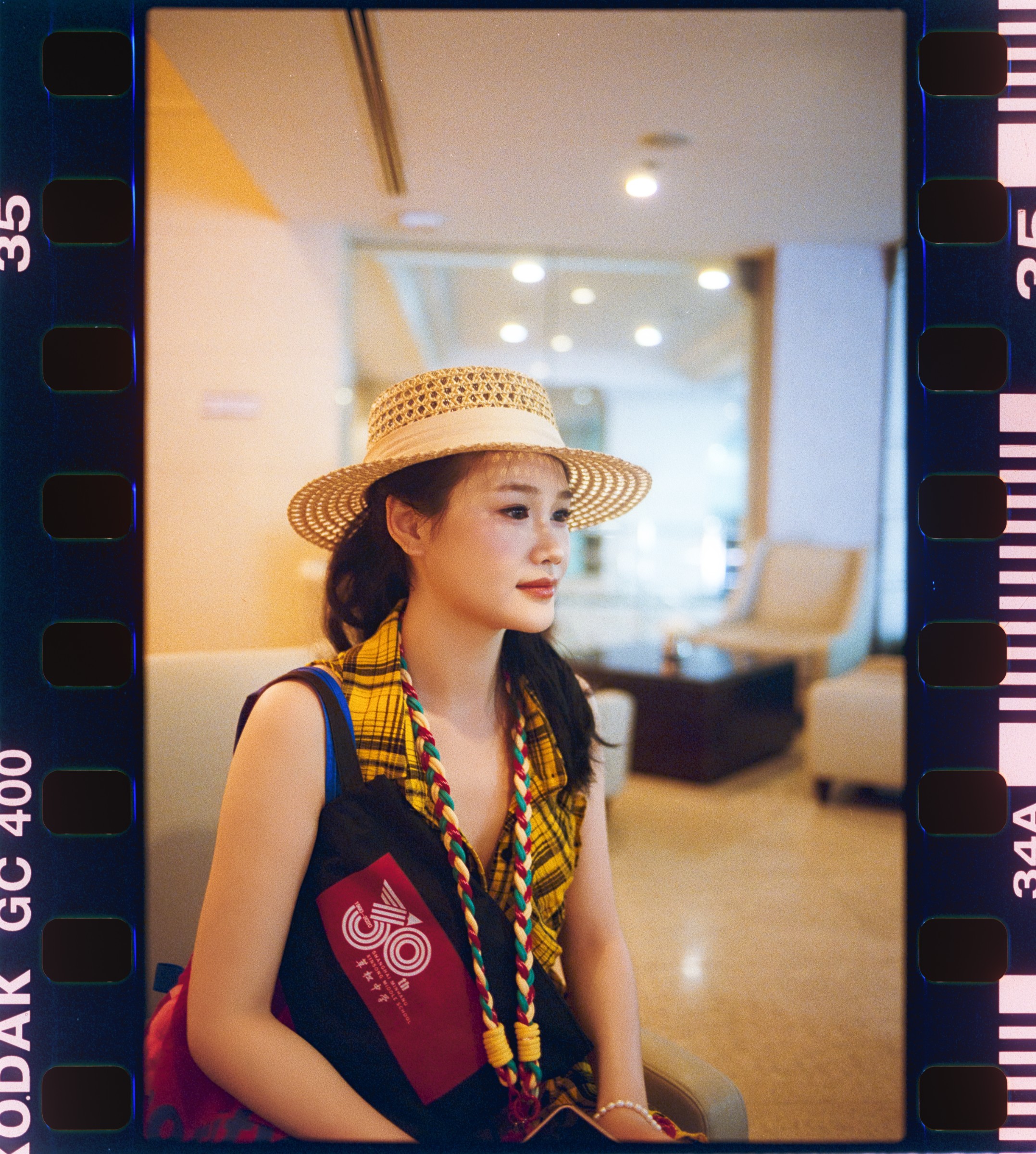 Film-framed portrait of a woman in a straw hat and patterned dress
